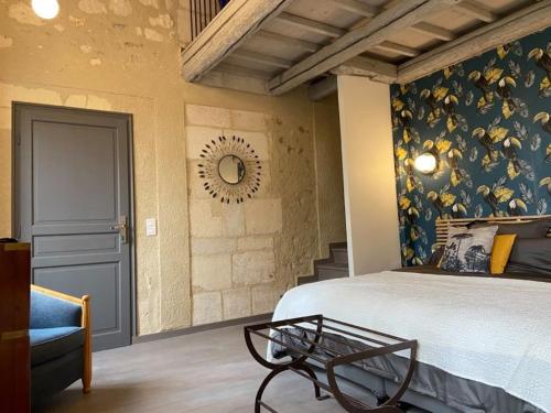 a bedroom with a bed and a chair and a table at Domaine Cap Rubis in Paradou