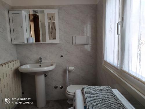 a bathroom with a sink and a toilet and a mirror at CASA VACANZE LUNA in Seriate