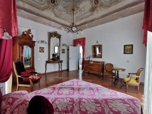1 dormitorio con cama rosa, mesa y sillas en Le Foglie Di Acanto, en Lucera