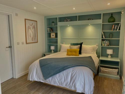 a bedroom with a large bed with green shelves at Littlebeads in Chichester