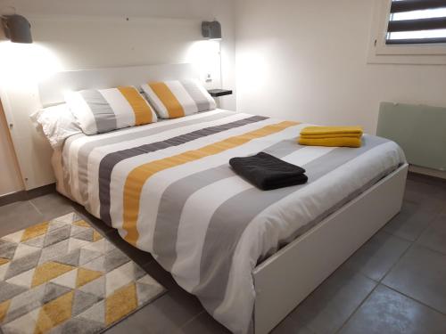 a bedroom with a large bed with yellow and white pillows at kérentrée - Appartement en centre ville avec terrasse et parking privé in Pont-lʼAbbé