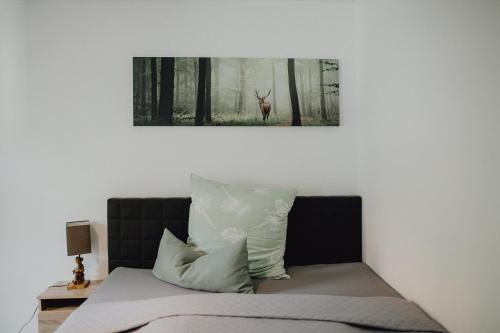 a bed with a picture of a deer on the wall at Stadt Land Fluss New Apartments by Zollhaus in Forchheim