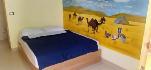 a bedroom with a painting on the wall at Ahmed Safari Camp in Bawiti