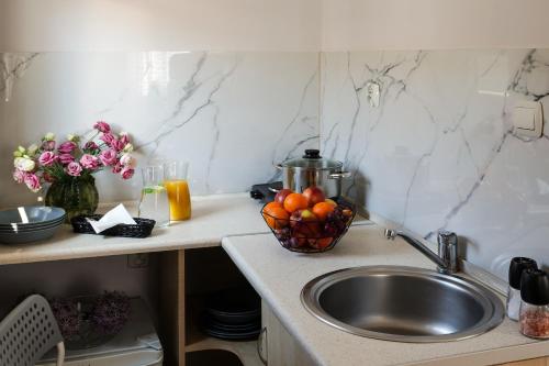 a kitchen counter with a sink and a bowl of fruit at Domki Bungalow Stella Resort & SPA in Władysławowo