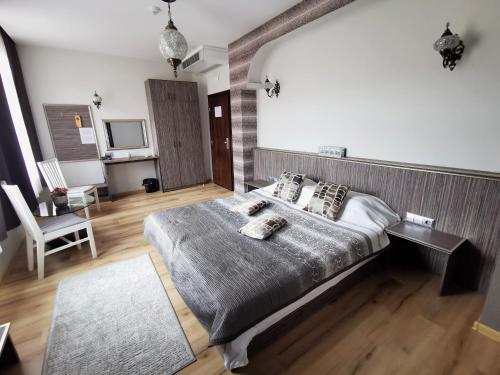 a bedroom with a bed and a chair and a television at Hotel Africa in Haskovo
