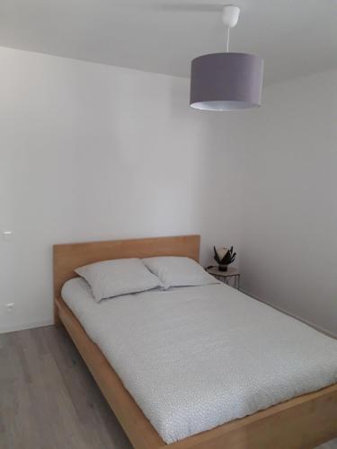 - une chambre dotée d'un lit avec un mur blanc dans l'établissement Beau T2 neuf au calme entre mer et montagne, à Bassussarry