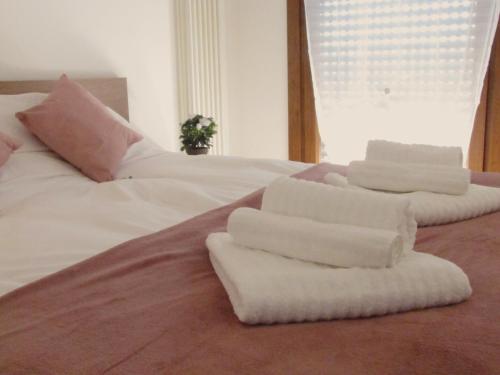 a bed with white blankets and pillows on it at Vicenza City Apartments 2 in Vicenza