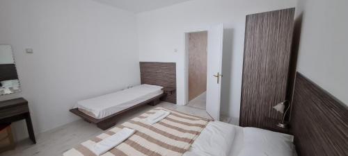 a small bedroom with a bed and a desk at Stars Palić in Palić