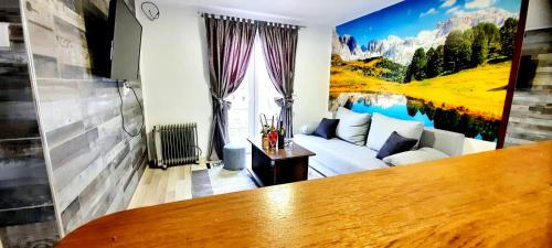 ein Wohnzimmer mit einer Couch und einem Gemälde an der Wand in der Unterkunft Sunce in Bajina Bašta