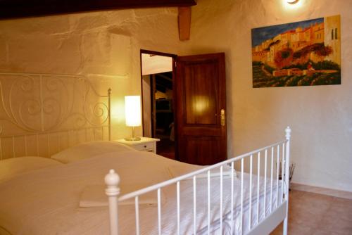 a bedroom with a large white bed and a staircase at Finca Can Rotger in Caʼs Concos