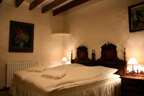 a bedroom with a white bed with two lamps on it at Finca Can Rotger in Caʼs Concos
