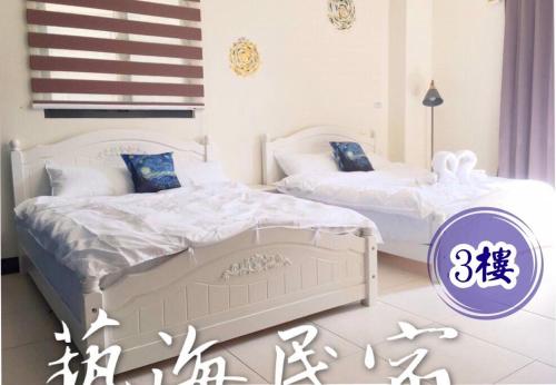 玉井區的住宿－玉井·藝海民宿，卧室内的两张床,紫色和白色