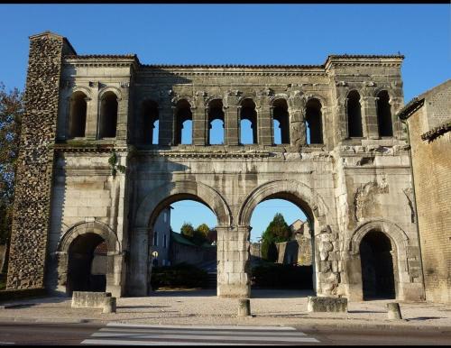an old building with arches in a courtyard at Chambres d'Hôtes Vadiera in Autun