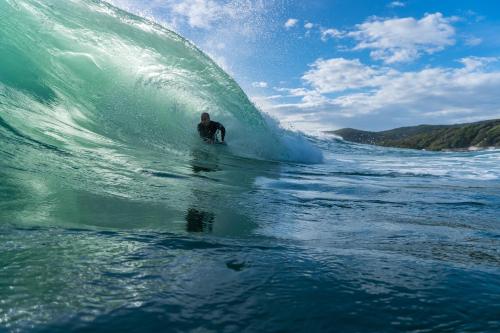 a man riding a wave on a surfboard in the ocean at Hotel Massimo in Marina di Cecina