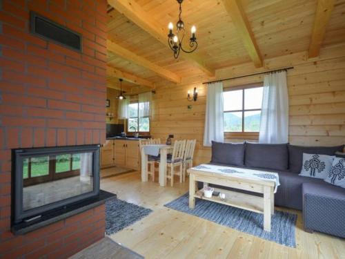 uma sala de estar com um sofá e uma lareira em KANADYJKA domki drewniane em Niedzica