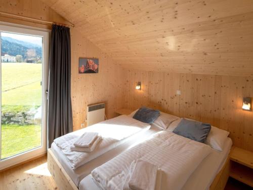LaßrchbergにあるChalet Sonnenblickの大きな窓付きの客室の大型ベッド1台分です。