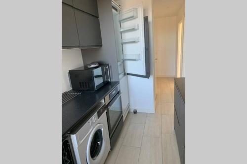 a kitchen with a microwave and a washer and dryer at 300 m to Metro: 5 min airport/12 min Copenhagen C in Copenhagen