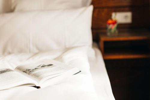 an open book on a bed with a night stand at Amtshaus Freinsheim in Freinsheim
