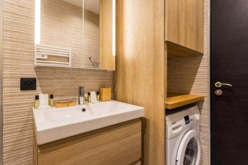une salle de bain avec un lavabo et une machine à laver dans l'établissement Nation-Charonne II Charming Apartment 1BR-4P, à Paris