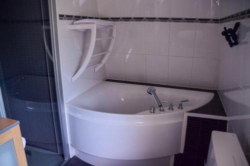 a white bath tub in a bathroom with a shower at Doeselie deux in Ronse