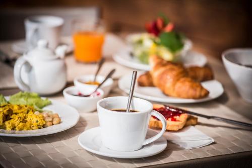 a table with plates of food and a cup of coffee at Salvadonica in San Casciano in Val di Pesa