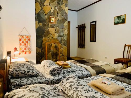 two beds in a room with a stone wall at Chalet Vedmezhe in Polyana