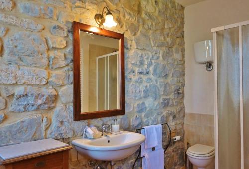 a stone bathroom with a sink and a mirror at Agriturismo I Gergoni in Monteleone dʼOrvieto