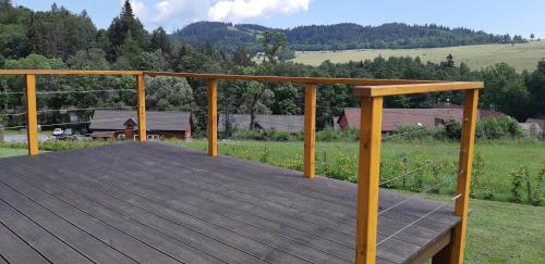a large wooden deck with a view of a field at Chata Karamelka in Dolní Moravice