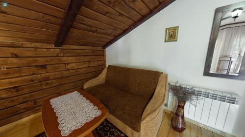 a living room with a chair and a table at Chalet Vedmezhe in Polyana