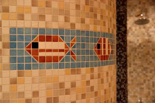 a tile wall with two fish on it at Hotel & Restaurant Seebrücke in Zingst