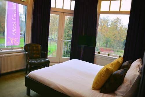 um quarto com uma cama, uma cadeira e janelas em DeVilla em Rijs