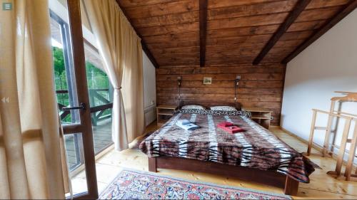a bedroom with a bed and a large window at Chalet Vedmezhe in Polyana