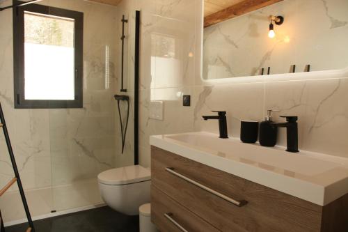 La salle de bains est pourvue d'un lavabo, de toilettes et d'un miroir. dans l'établissement La Pieuca, aux Contamines-Montjoie