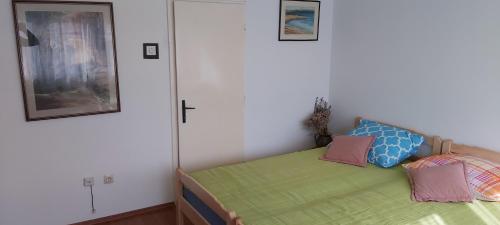 a bed with two pillows on it in a room at Apartman Ljubica in Daruvar