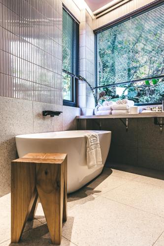 a bathroom with a tub and a table and a window at Jiufen 35 in Jiufen
