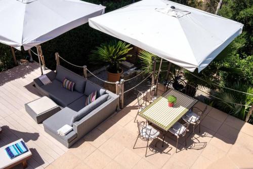 a patio with a couch and a table with an umbrella at Nice villa Marpessa in Portals Nous with pool in Portals Nous