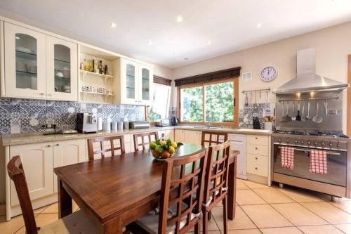 a large kitchen with a wooden table and chairs at Nice villa Marpessa in Portals Nous with pool in Portals Nous