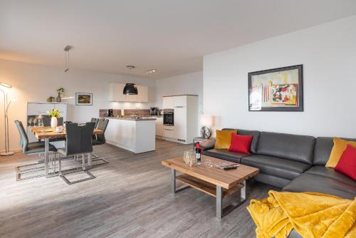 GarzにあるAppartement "Haffglück" mit Penthouseflair - Oase am Haffのソファとテーブルのあるリビングルームとキッチン