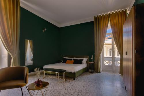 ein Schlafzimmer mit einem Bett und einer grünen Wand in der Unterkunft Quatrum Napoli - B&B in Neapel