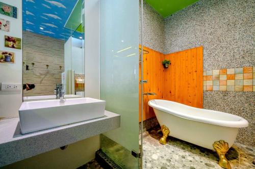 une salle de bains avec lavabo et baignoire dans l'établissement Lazy Cat, à Luodong