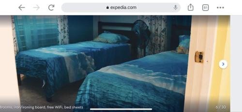 two beds with blue sheets in a room at Casa Peace Haven Beach House Aguada in Aguada