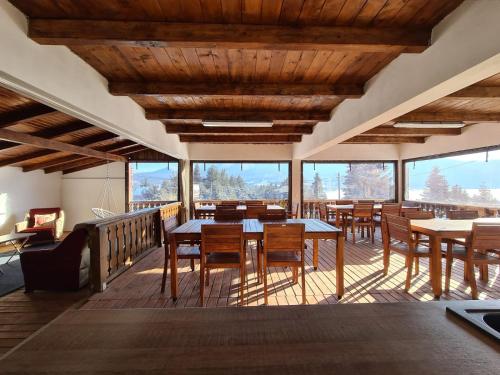 Pensiunea Encian في كوليبيتا: غرفة طعام مع طاولات وكراسي ونوافذ