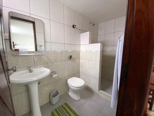 a bathroom with a sink and a toilet and a mirror at Hotel Pousada da Praça in Recife
