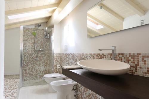 bagno con lavandino, servizi igienici e specchio di Villa Mony. 100 mt dal mare! a Pietrasanta