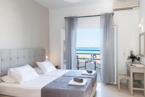 a hotel room with a large bed and a large window at Ammos Apartments in Kavos