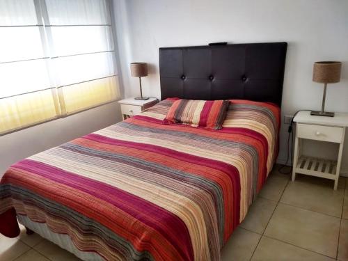 a bedroom with a large bed with a colorful blanket at Departamento de dos dormitorios para 6 personas en el centro in Buenos Aires