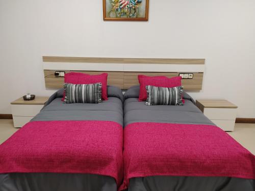 - une chambre avec un grand lit et des oreillers roses dans l'établissement El LEGADO, à Andújar