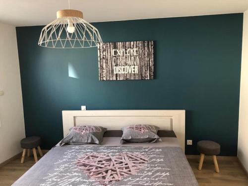 een slaapkamer met een bed met een blauwe muur bij La maison du bonheur proche plage composée de 2 appartement et d'une belle terrasse in Étaples