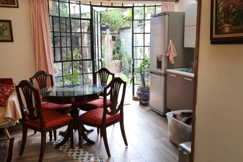 a kitchen with a table and chairs and a refrigerator at Majikal B&B - La Doña in Cholula