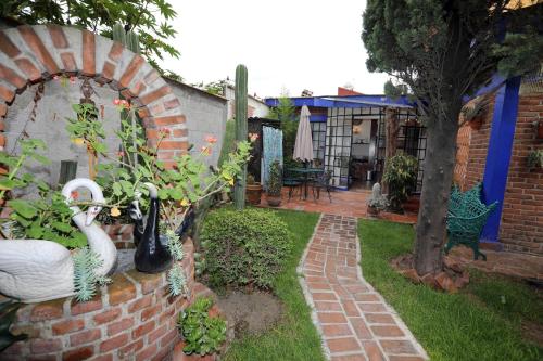a garden with a brick wall and a patio at Majikal B&B - La Doña in Cholula